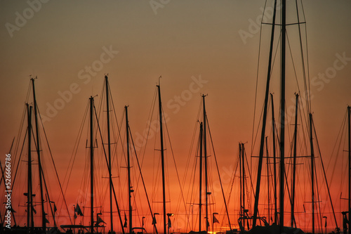 Yacht masts and rigging in silhouette at sunset