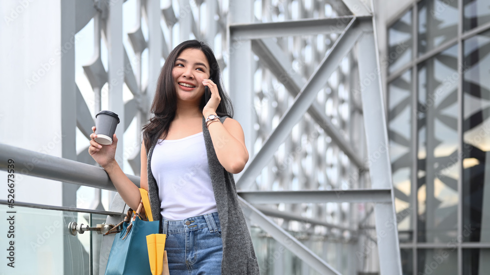Stylish young woman talking to friends on mobile phone while on terrace of modern building. Lifestyle concept Stylish young woman talking to friends on mobile phone while on terrace of modern building. Lifestyle concept
