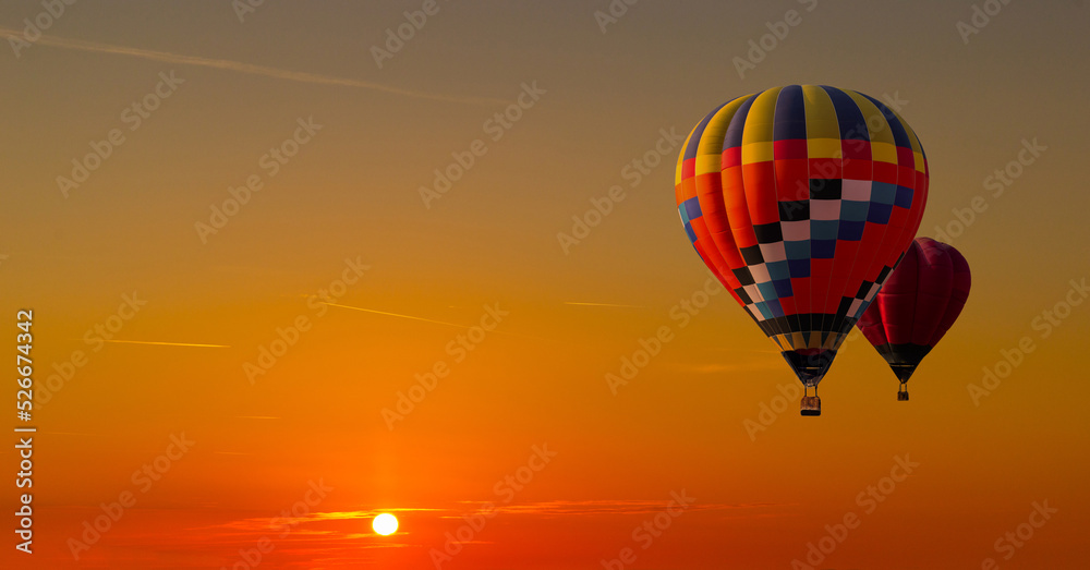 Colorful hot air balloons flying on the sunset sky background.