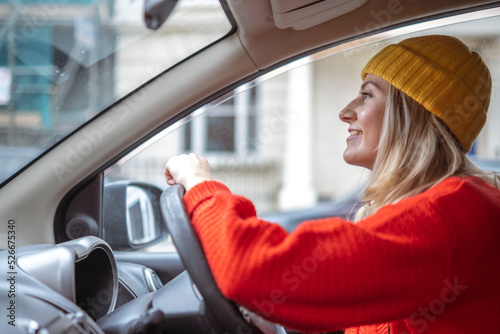 Smiling woman in knit hat driving car photo