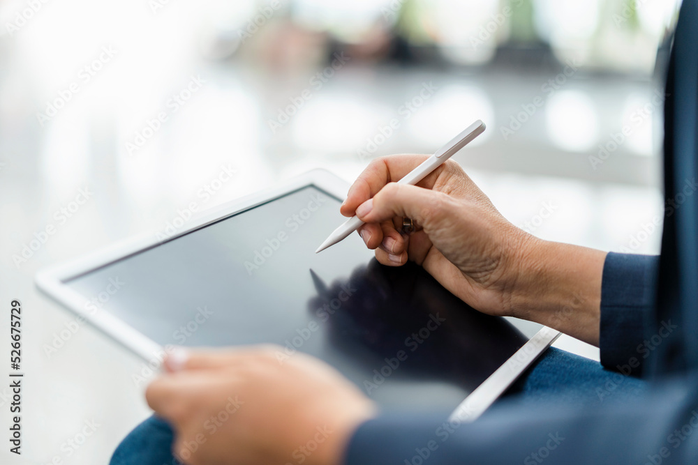 Businesswoman using digitized pen on tablet PC Businesswoman using digitized pen on tablet PC