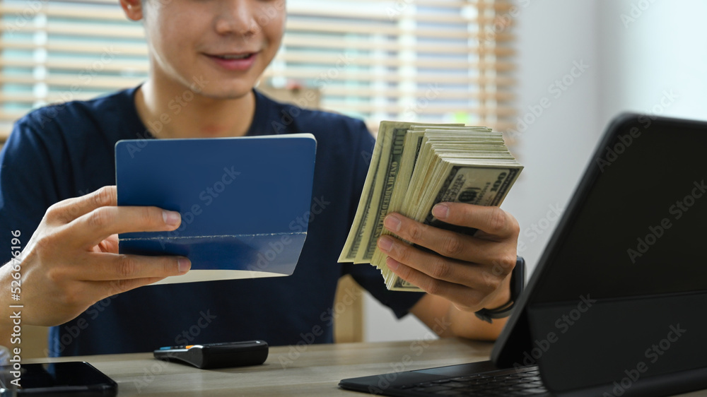 Smiling millennial man managing household expenses expenditures in living room