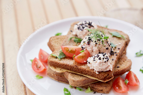 Seasonal sandwiches with sourdough bread, tomatoes, herbs, quinoa and vegan sause. Healthy vegan breakfast