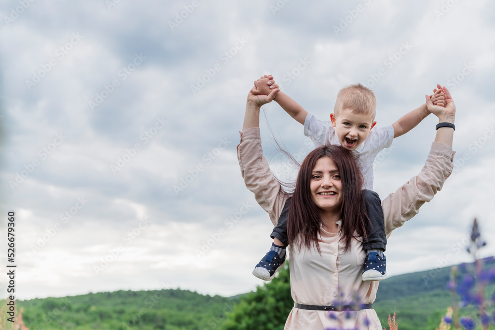 Smiling mother carrying son on shoulders Smiling mother carrying son on shoulders