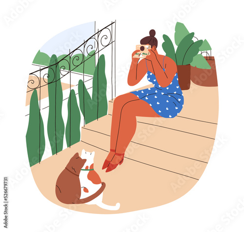 Woman taking photo of cute cats outdoors on summer holiday. Young girl shooti...