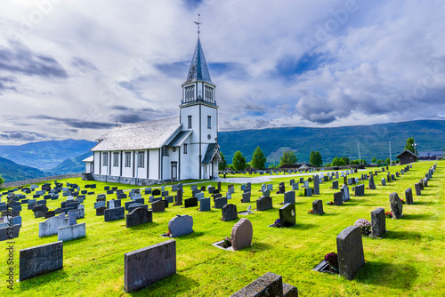Norway, Viken, Gol, Rows of tombstones with rural church in background photo