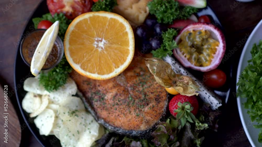 Rustic seafood steak salmon fillet grill serve with fruits orange passion fruit and salad top view Rustic seafood steak salmon fillet grill serve with fruits orange passion fruit and salad top view