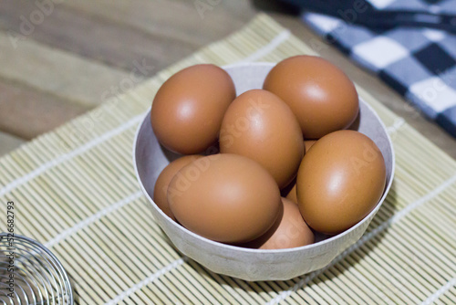 Brown eggs in bowl on a rustic wooden background with copy space. Selective focus