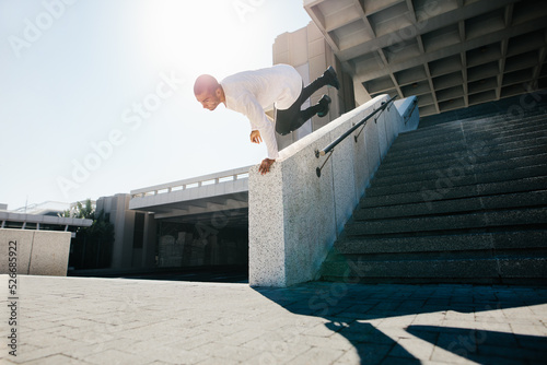 Young man practicing parkour in urban space photo