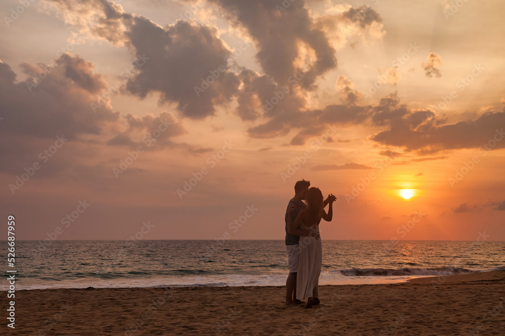 Silhouette lovely couple holding hands on tropical sandy beach at sea sunset background. Happy man and woman dancing happiness. Joyful couple enjoying summer at ocean coastline. Copy text space