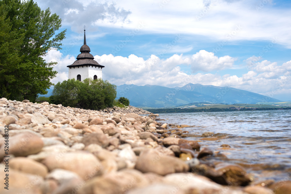 Water reservoir Liptovska Mara in the Slovakia. Old church in the Liptov region with Tatras background.