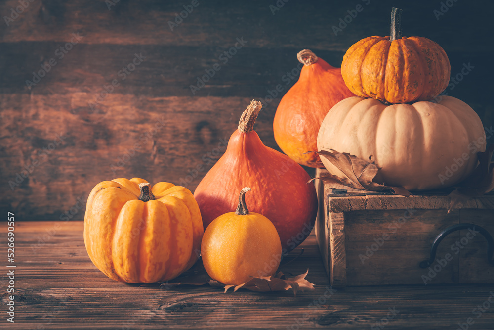 Rustic autumn still life with pumpkins and golden leaves on a wooden surface - obrazy, fototapety, plakaty 