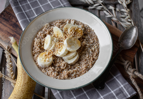 Breakfast cereal porridge with oats, amaranth, quinoa and bananas, nuts and maple syrup
