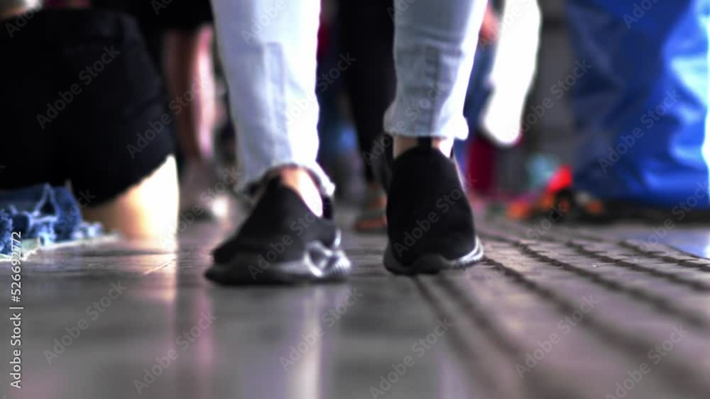 Crowd of people's feet wearing casual footwear walking in slow motion indoors Crowd of people's feet wearing casual footwear walking in slow motion indoors