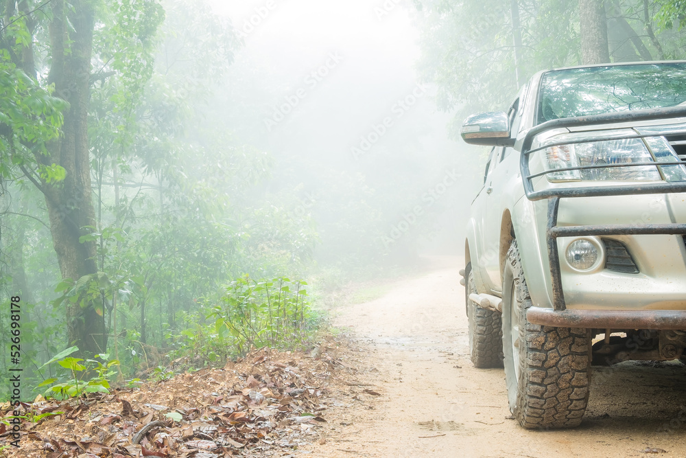 Wheel truck closeup in countryside landscape with muddy road. Extreme adventure driving 4x4 vehicles for transport or travel or off-road races in outdoor nature. 4wd tire automobile on dirt mountain.