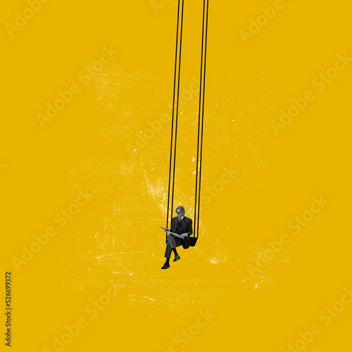 Contemporary art collage. Conceptual image. Young man sitting on swing and reading isolated on yellow background photo