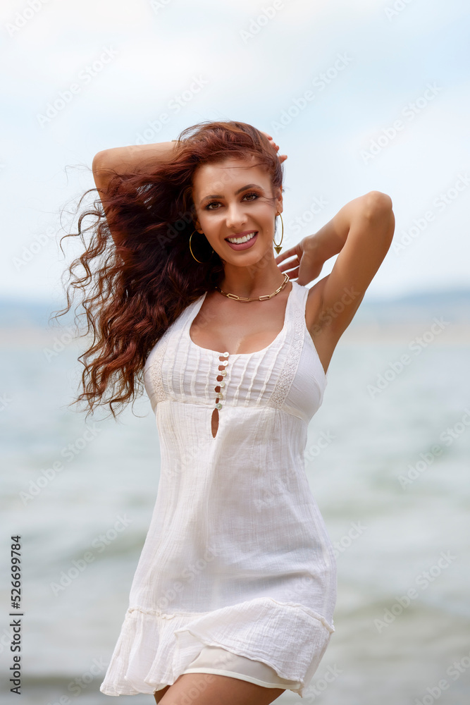 Portrait of a beautiful brunette woman in a white dress at the beach Portrait of a beautiful brunette woman in a white dress at the beach