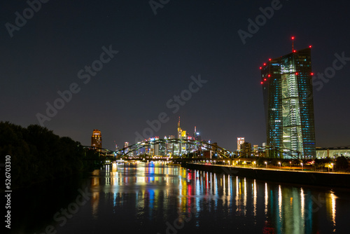 Europäische Zentralbank mit Frankfurter Skyline in der Nacht