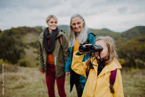 Tablou canvas Small girl with mother and grandmother hiking outoors in nature.