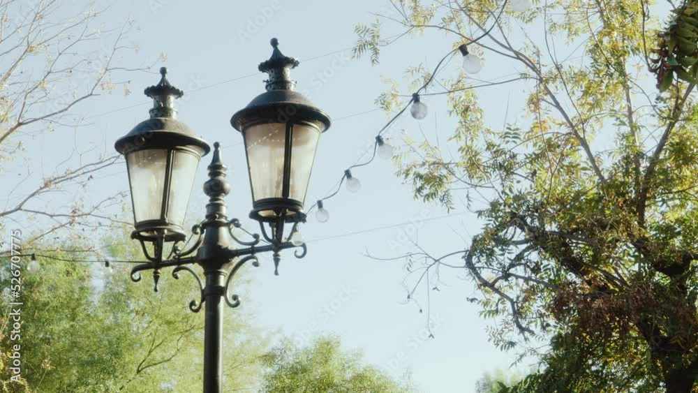 Streetlights strung with lights, panning shot. Beautiful old lamps during daytime. Shot on 5k RED GEMINI. Streetlights strung with lights, panning shot. Beautiful old lamps during daytime. Shot on 5k RED GEMINI.