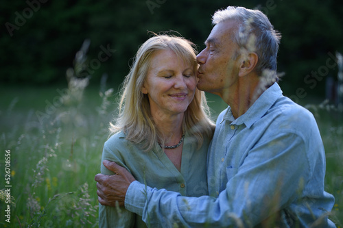 фотографія Portrait of affectionate senior couple kissing in nature.