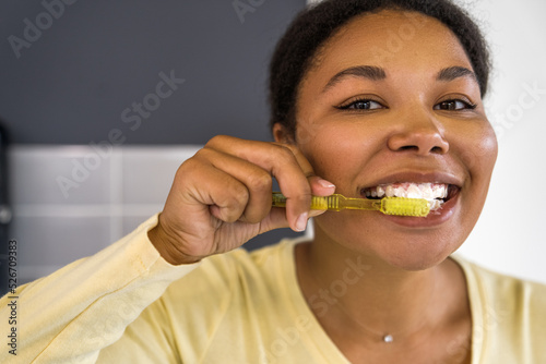 Happy girl with wide smile brush her healthy teeth after whitening procedure