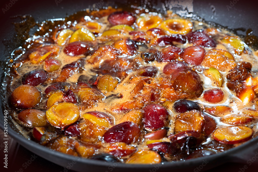 The process of boiling plum jam in a cast iron pan The process of boiling plum jam in a cast iron pan