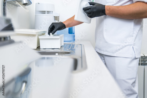 Male stomatologist wearing protective gloves preparing to the patient at his clean office
