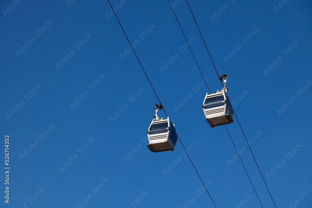 A pair of sky lift cabins in front of a clear blue sky. Tbilisi, Georgia. A pair of sky lift cabins in front of a clear blue sky. Tbilisi, Georgia.