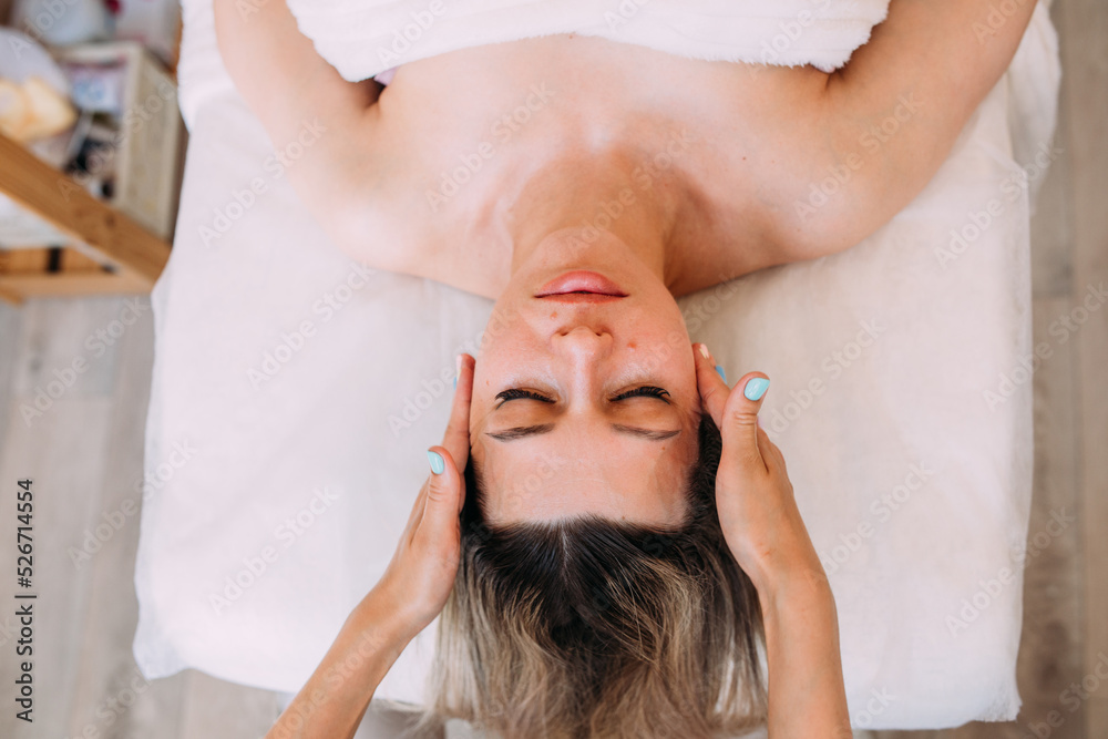 Naklejka premium Cosmetologist does facial massage for woman. Beauty skin care