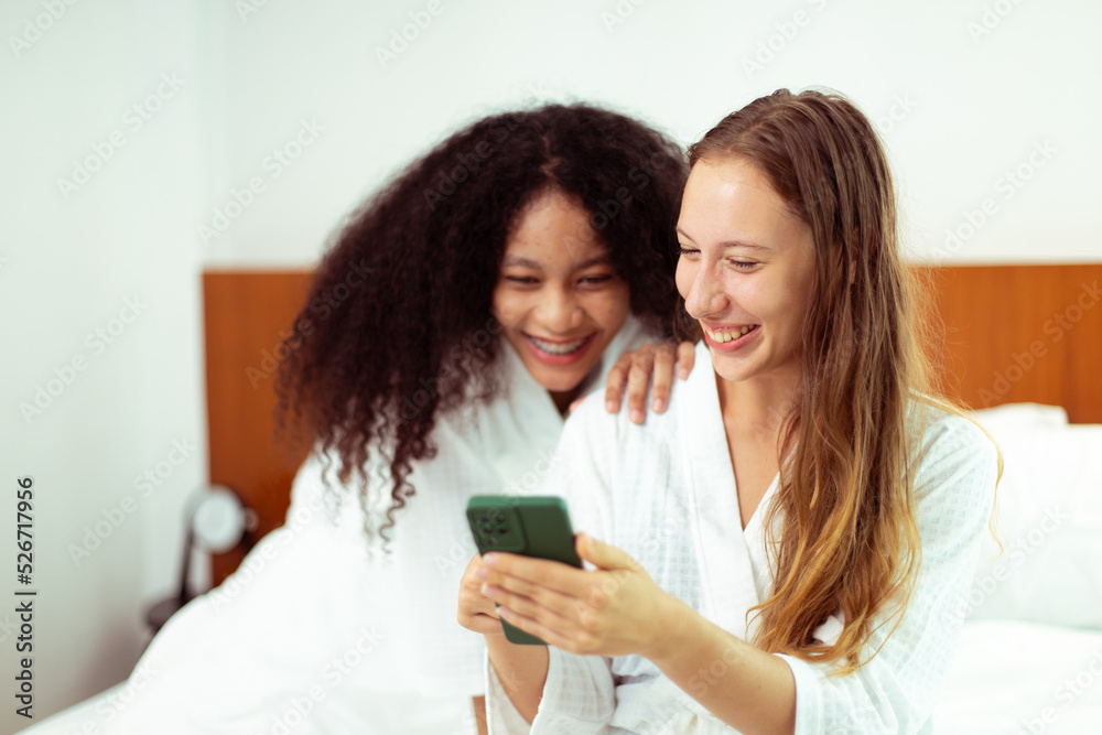Caucasian and black women love together and hug hold as diversity person. Young Adult Romantic couple look at smart phone photo chat text as feeling happy smile togetherness and diversity, copy space Caucasian and black women love together and hug hold as diversity person. Young Adult Romantic couple look at smart phone photo chat text as feeling happy smile togetherness and diversity, copy space