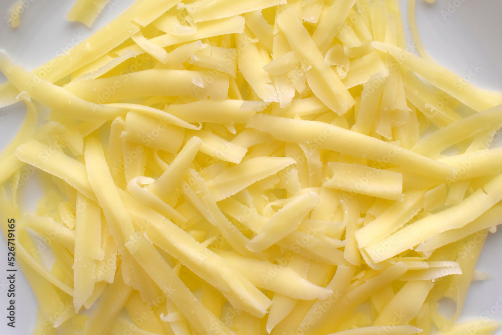 Grated cheese on a white plate. 