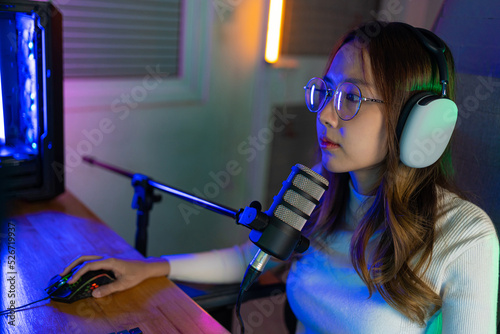 Gamer and E-Sport online of Asian woman playing online computer video game with lighting effect, broadcast streaming live at home. Gamer and E-Sport online gaming technology Championship tournament.