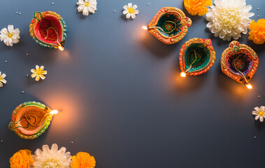 Happy Diwali - Clay Diya lamps lit during Diwali, Hindu festival of lights celebration. Colorful traditional oil lamp diya on blue background