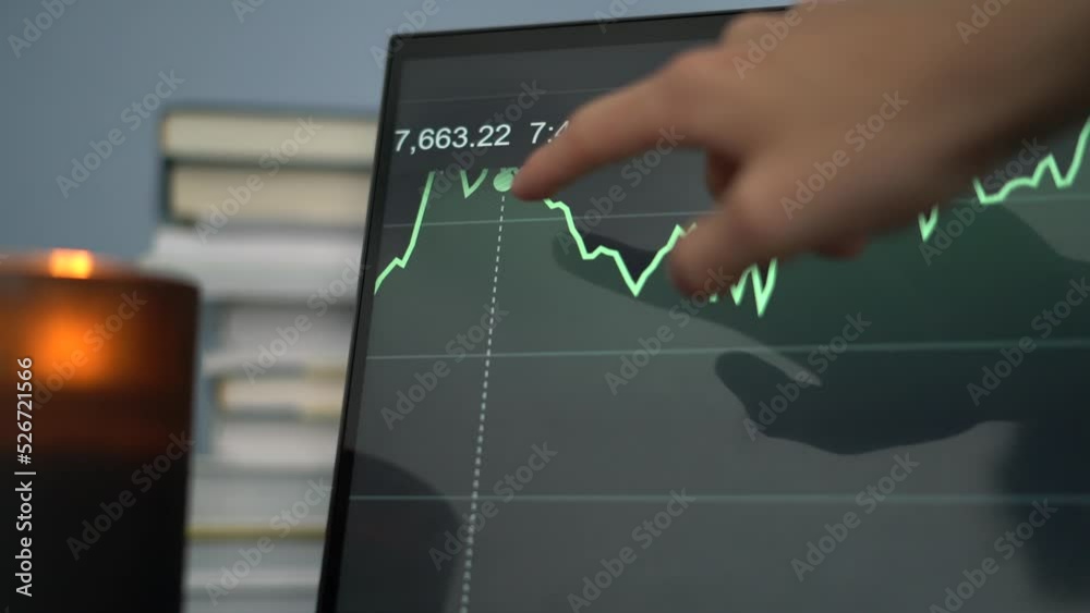 Close up touch screen computer analysing stock market with moving graph