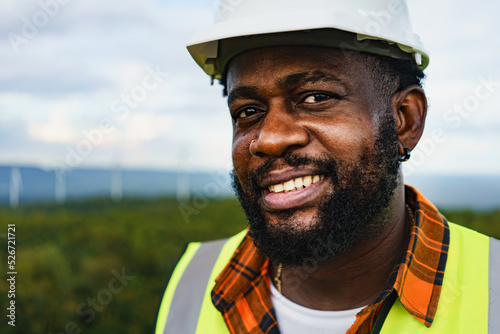 Close up portrait of black optimistic engineer man smiling to camera while working outdoor.