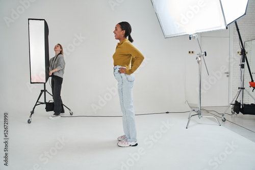 Multiracial woman laughing out loud while waiting for her photographer