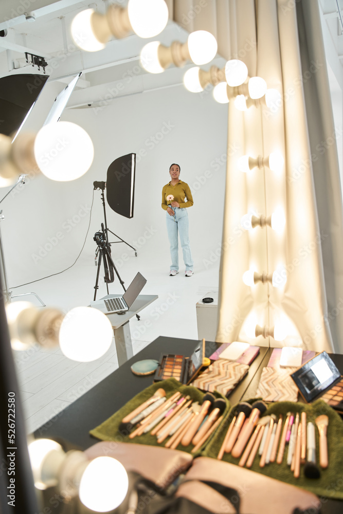 Multiracial girl standing at the studio with soft box and waiting for the shooting Multiracial girl standing at the studio with soft box and waiting for the shooting