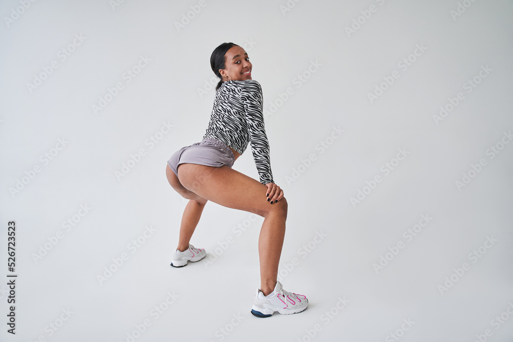 Overjoyed woman with stretch marks at her buttocks twerking and smiling