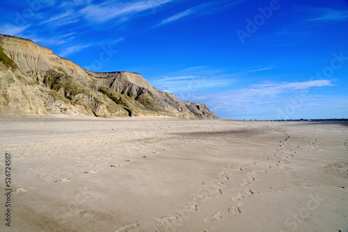 Klippe und leerer Strand bei Ferring an der Nordseeküste Dänemarks in perfektem Abendlicht vor blauem Himmel mit einigen Wolken am Horizont, Urlaub, Idylle, Freiheit, Reisen