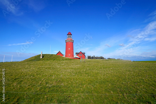 famous Bovbjerg Fyr lighthouse on the North Sea coast of Denmark in perfect light in front of a blue sky with some clouds at the horizon, high quality image, landmark, travel, tourism, attraction	 photo