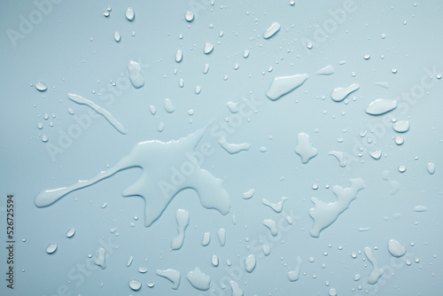 Spilled water on a gray surface, in the form of beautiful splashes. Abstract background. Top view. 