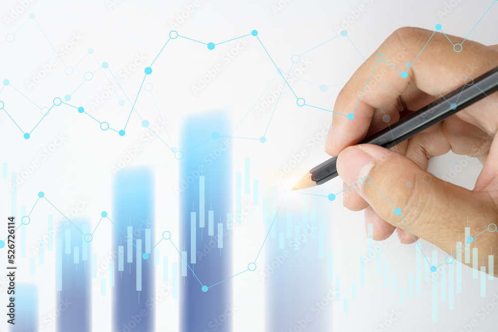 Hand holding pencil points to the graph analysis on monitor screen, Economic and financial concept, Business concept - Financial graphs drawn with pencil. Hand holding pencil points to the graph analysis on monitor screen, Economic and financial concept, Business concept - Financial graphs drawn with pencil.