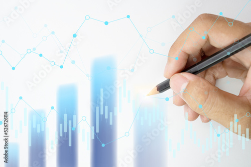 Hand holding pencil points to the graph analysis on monitor screen, Economic and financial concept, Business concept - Financial graphs drawn with pencil.