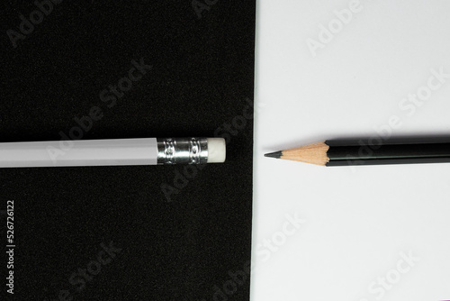 Wooden pencils, Black pencil turn pencil head to eraser of white pencil with black and white background, Contrast concept, School and office concept. photo