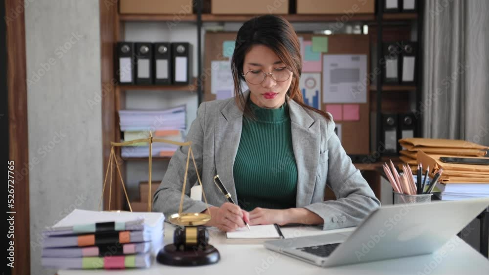 justice and law concept. asian woman lawyer working and judge in a courtroom the gavel, working with smart phone and laptop and digital tablet computer on wood table justice and law concept. asian woman lawyer working and judge in a courtroom the gavel, working with smart phone and laptop and digital tablet computer on wood table