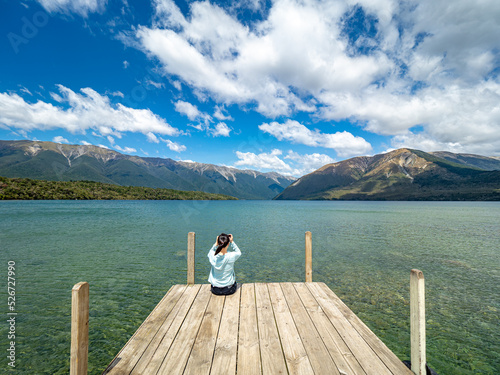 A girl is taking photos of Kerr Bay at Lake Rotoiti in Nelson Lakes National Park, New Zealand.