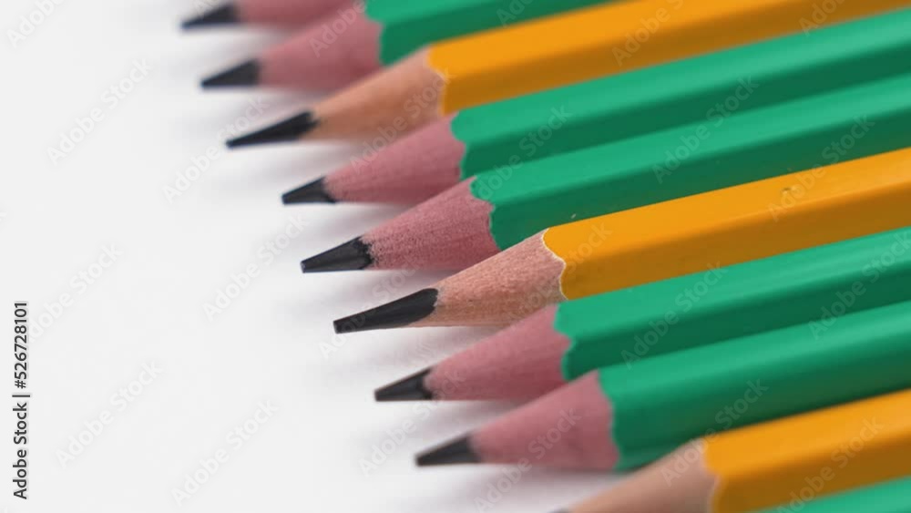 Sharpened graphite green and yellow simple pencils on a white background close-up. Rotation. Back to school and stationery concept. Sketching set Sharpened graphite green and yellow simple pencils on a white background close-up. Rotation. Back to school and stationery concept. Sketching set