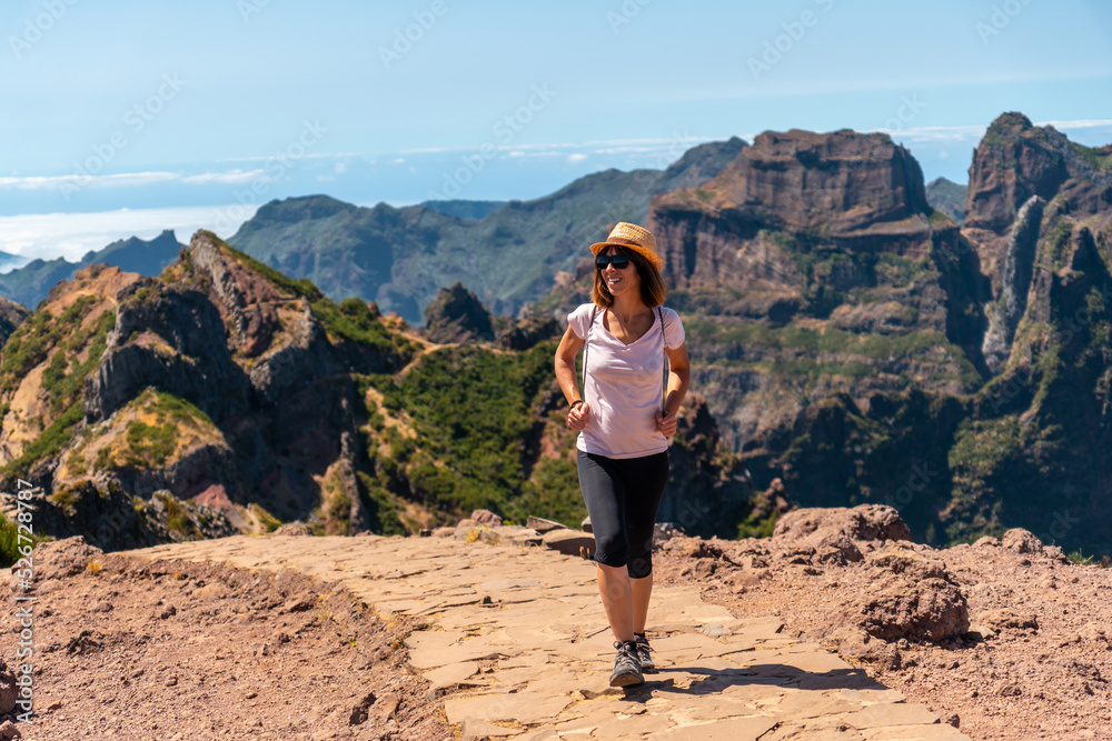 Naklejka premium A tourist walking on the trekking trail at Pico do Arieiro in summer, Madeira. Portugal