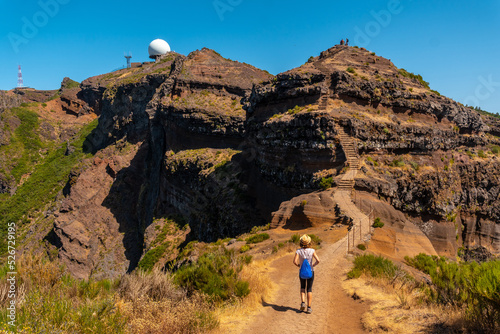 A young woman on the trail to Pico do Arieiro from Ninho da Manta viewpoint, Madeira. Portugal